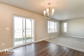 Colorado Springs house for rent - A room with a chandelier, a carpet, and a sliding glass door.