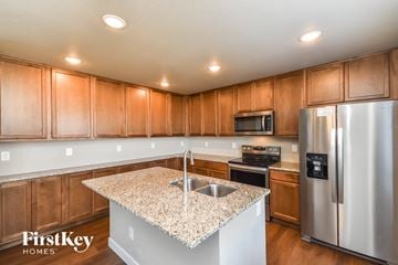 Colorado Springs house for rent - A kitchen with wooden cabinets and a granite countertop.