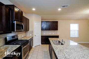 Schertz house for rent - a kitchen with granite counter tops and black cabinets