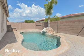 Vail house for rent - A small pool with a waterfall and a palm tree in the background.