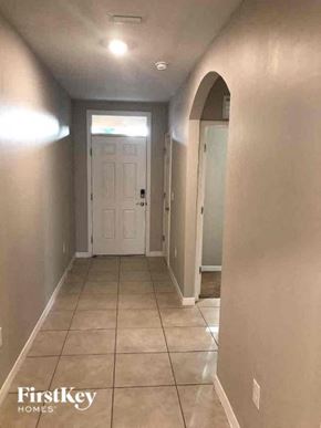 Fort Myers house for rent - a hallway with a tiled floor and a white door