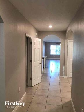 Fort Myers house for rent - a hallway with a white door and a tiled floor