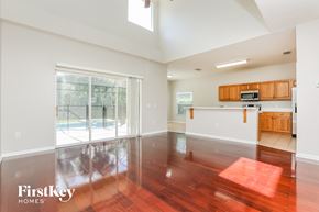 Kissimmee house for rent - an empty living room and kitchen with wood flooring and a pool
