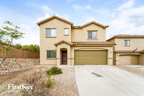 Tucson house for rent - a beige house with a garage and a driveway