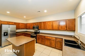 Tucson house for rent - a large kitchen with wood cabinets and stainless steel appliances