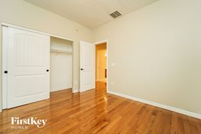 Tucson house for rent - a bedroom with two closets and a hard wood floor