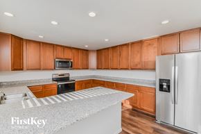 Colorado Springs house for rent - a kitchen with granite countertops and wooden cabinets and stainless steel appliances