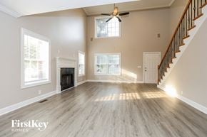 Murfreesboro house for rent - A spacious living room with a fireplace and a staircase.