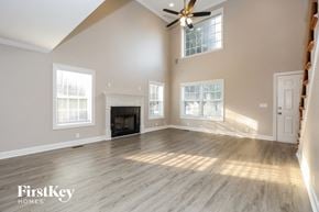 Murfreesboro house for rent - A spacious room with a fireplace and a ceiling fan.
