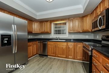 Murfreesboro house for rent - A kitchen with wooden cabinets and a stainless steel refrigerator.