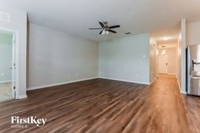 Davenport house for rent - A spacious room with wooden floors and a ceiling fan.
