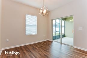 Davenport house for rent - A room with wooden floors and a sliding glass door leading to a balcony.