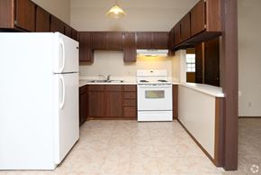Stow apartment for rent - an empty kitchen with white appliances and wooden cabinets