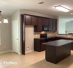 Little Elm house for rent - an empty kitchen with dark cabinets and a counter top