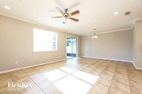 Jacksonville house for rent - A spacious room with a ceiling fan and large windows.