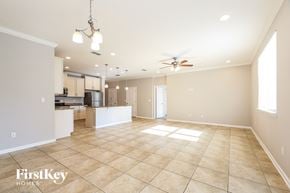 Jacksonville house for rent - A spacious living room with a kitchen in the background and a ceiling fan above.