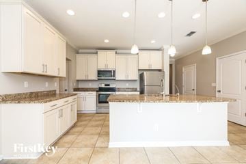 Jacksonville house for rent - A kitchen with white cabinets and appliances.