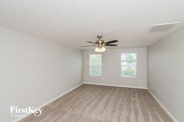 Melbourne house for rent - a spacious living room with carpet and a ceiling fan