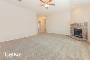 Forney house for rent - A spacious living room with a fireplace and a ceiling fan.