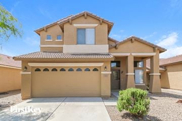 Buckeye house for rent - a tan house with a garage and a driveway