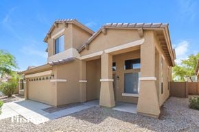 Buckeye house for rent - a beige house with a driveway in front of it