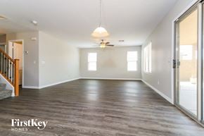 Buckeye house for rent - an empty living room with wood floors and a ceiling fan