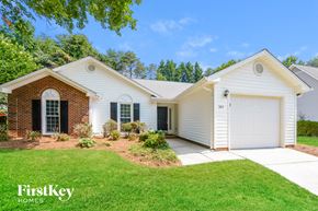 Greensboro house for rent - a white house with a white garage door and a lawn