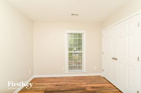Greensboro house for rent - a bedroom with white walls and a window and wood floors