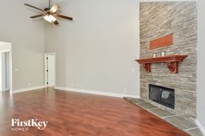 Clarksville house for rent - a living room with a fireplace and a ceiling fan