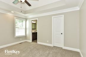 Clarksville house for rent - a bedroom with a ceiling fan and a door to the bathroom