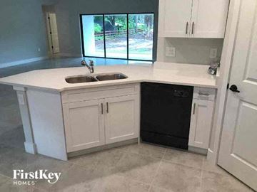 Fort Myers house for rent - a white kitchen with a sink and a window
