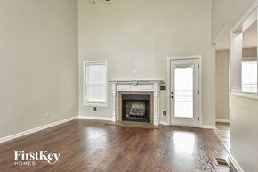 Clarksville house for rent - an empty living room with a fireplace and a door