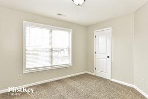 Clarksville house for rent - an empty bedroom with a window and a white door