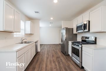 Conroe house for rent - A kitchen with white cabinets and stainless steel appliances.