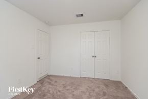 Conroe house for rent - A bedroom with a carpeted floor and two white doors.