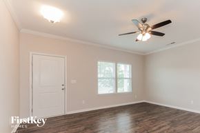 Gastonia house for rent - the bedroom has a ceiling fan and a white door