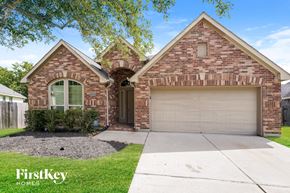 Fresno house for rent - A brick house with a garage door and a window.