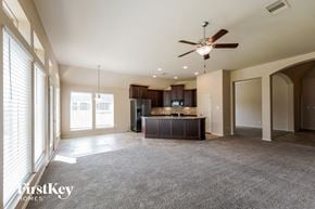 Fresno house for rent - A spacious living room with a ceiling fan and a bar area.