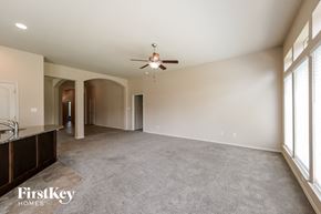 Fresno house for rent - A spacious room with a ceiling fan and large windows.