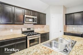 Fort Worth house for rent - a kitchen with stainless steel appliances and granite counter tops