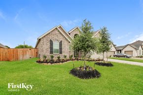 Rosharon house for rent - A house with a well-maintained lawn and a tree in the front yard.