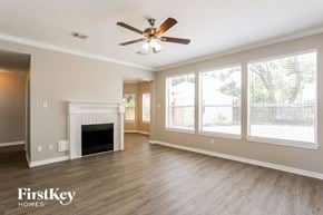 Houston house for rent - A spacious living room with a fireplace and a ceiling fan.