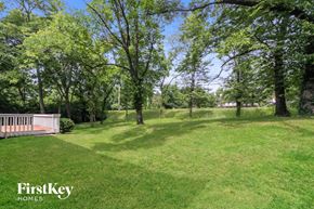 Sharonville house for rent - a large yard with trees and a wooden deck