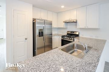 San Antonio house for rent - a kitchen with granite counter tops and a stainless steel refrigerator