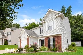 Charlotte house for rent - A house with a white siding and a red brick chimney.