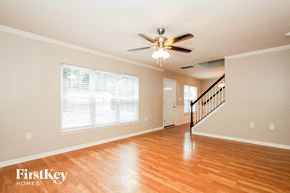 Charlotte house for rent - A spacious room with a wooden floor and a staircase.
