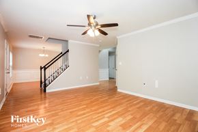 Charlotte house for rent - A spacious room with a staircase and a ceiling fan.
