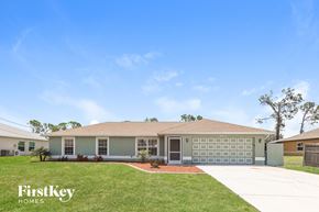 Englewood house for rent - a beige house with a lawn and a driveway