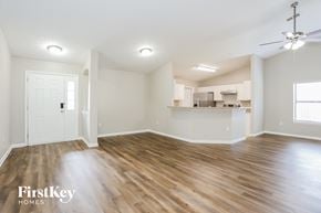 Jacksonville house for rent - an empty living room with wood flooring and a kitchen