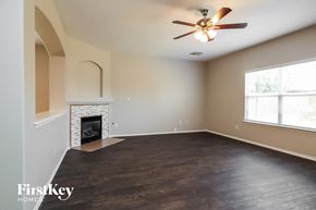 Tomball house for rent - a living room with a fireplace and a ceiling fan
